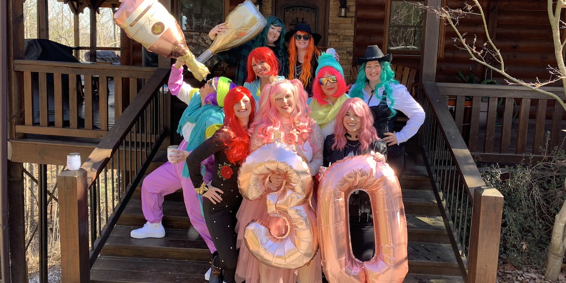 A group of people dressed up in colorful clothes celebrating outside a winery.